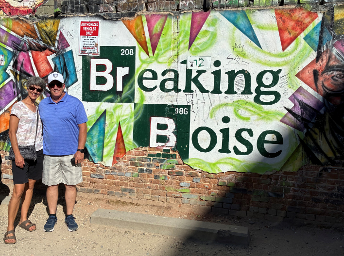 Pam and Andy smiling and posing in front of graffiti