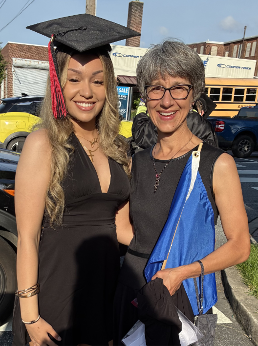 Pam with her arm around a graduating student