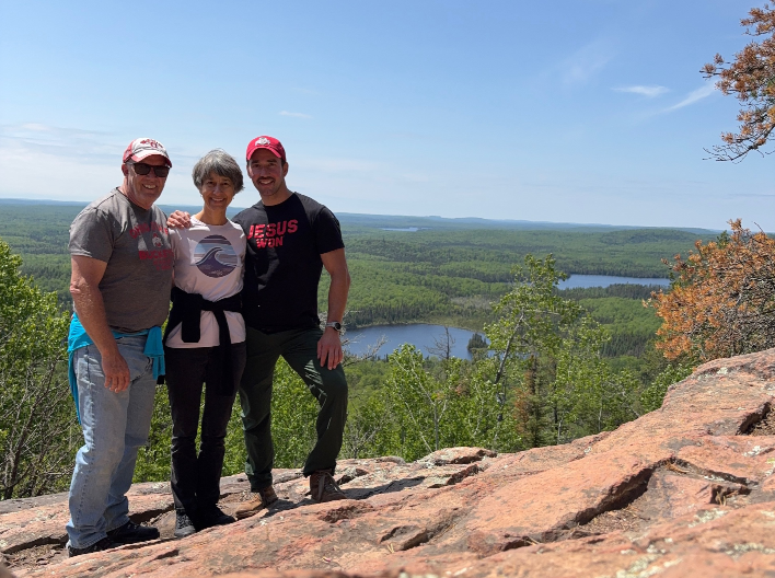 Andy, Pam, and Jake standing atop a mountain
